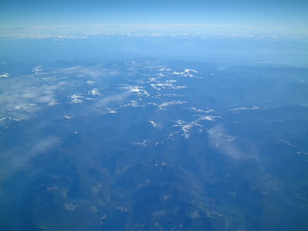機内の窓から見下ろす雲と海